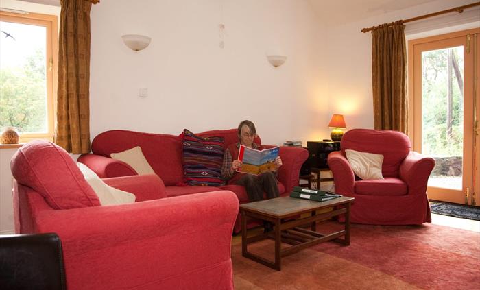 Sitting room with windows to the west and south. TV and DVD, radio, mobile wifi, books and games, woodburner and logs